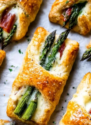 Asparagus Puff Pastry Bundles on a serving plate garnished with herbs
