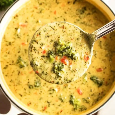 Creamy Broccoli Cheddar Soup in a bowl, garnished with cheese and broccoli florets