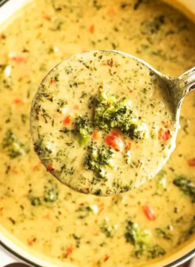 Creamy Broccoli Cheddar Soup in a bowl, garnished with cheese and broccoli florets