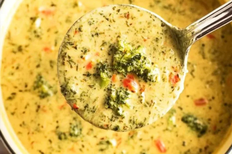 Creamy Broccoli Cheddar Soup in a bowl, garnished with cheese and broccoli florets