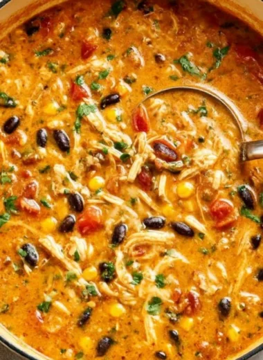 Bowl of creamy chicken tortilla soup topped with crispy tortilla strips and cilantro
