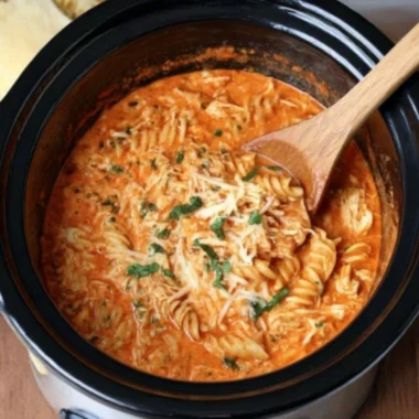 Creamy chicken parmesan soup made in a crock pot, garnished with cheese and herbs