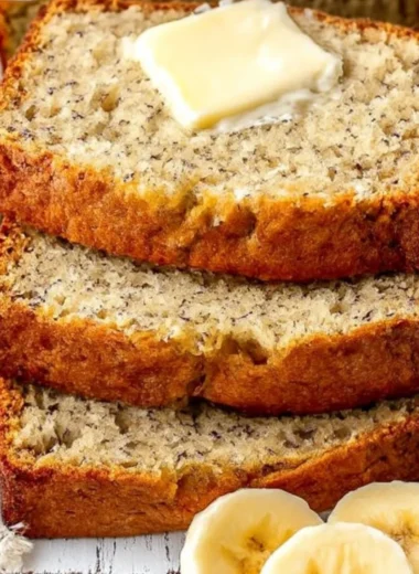 A loaf of easy moist banana bread with slices cut, showcasing its soft texture.