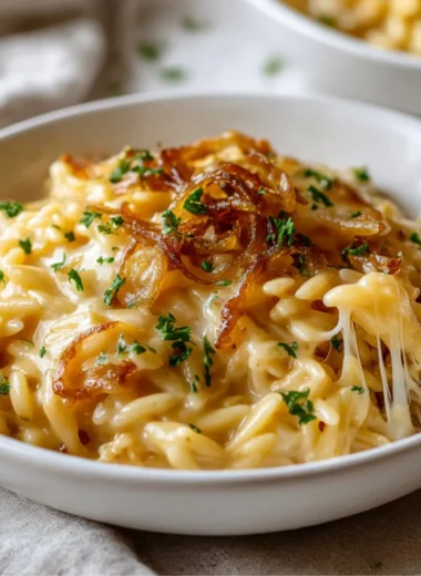 Delicious French Onion Orzo Bake topped with melted cheese and herbs
