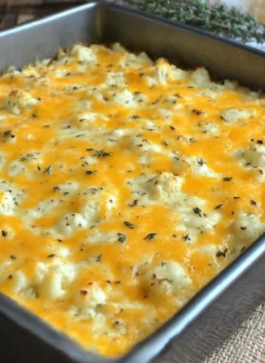 A serving of green chile cauliflower casserole topped with cheese