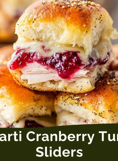 Havarti cranberry turkey sliders garnished with fresh herbs on a platter.
