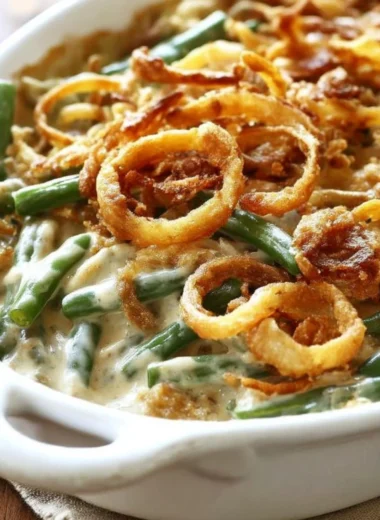 Homemade green bean casserole topped with crispy onions and served in a dish.