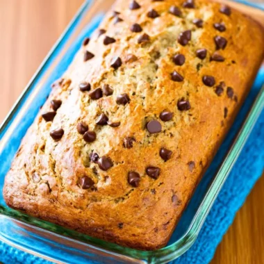 Protein banana bread slice with nuts and bananas on a wooden table