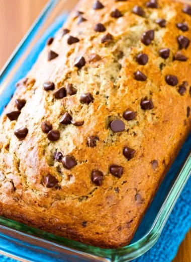 Protein banana bread slice with nuts and bananas on a wooden table