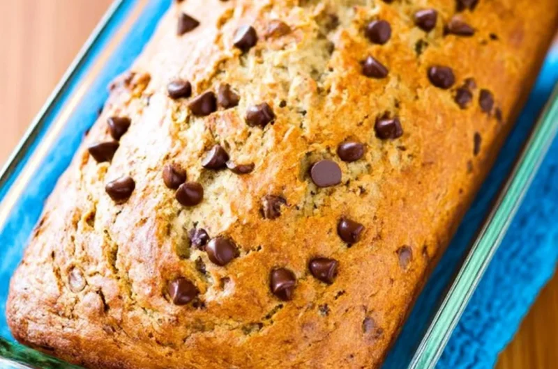 Protein banana bread slice with nuts and bananas on a wooden table