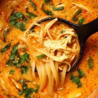 Bowl of flavorful Thai inspired chicken soup with herbs and spices