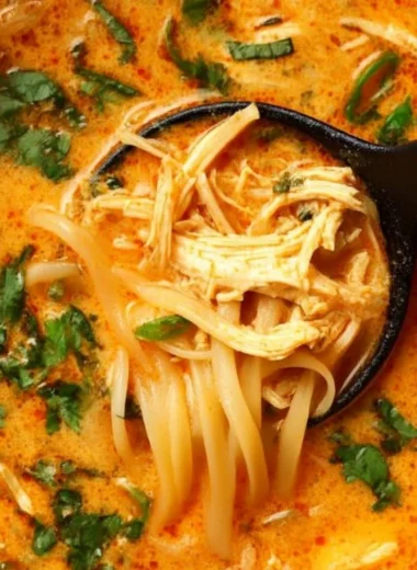 Bowl of flavorful Thai inspired chicken soup with herbs and spices