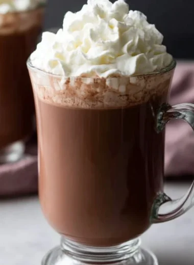 A rich cup of homemade hot chocolate topped with whipped cream and chocolate shavings