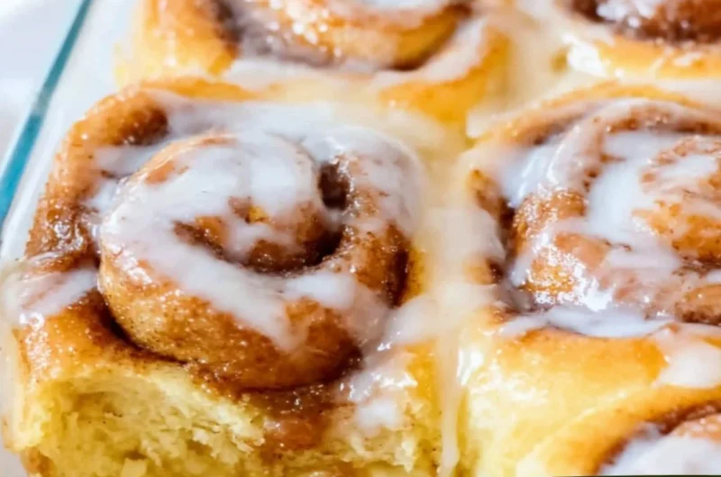 Delicious viral TikTok cinnamon rolls drizzled with icing on a plate.