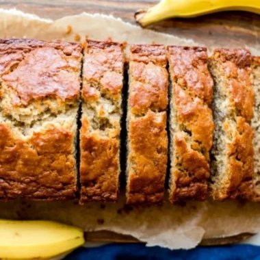 Delicious homemade banana bread sliced on a wooden cutting board