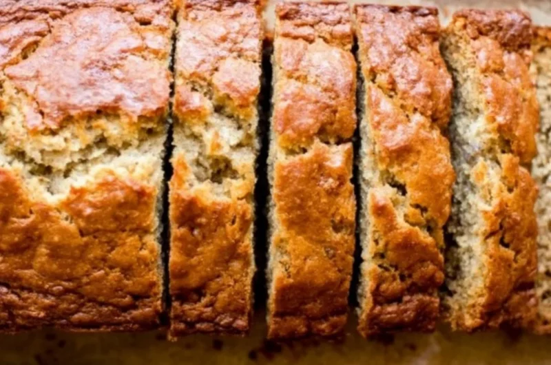 Delicious homemade banana bread sliced on a wooden cutting board