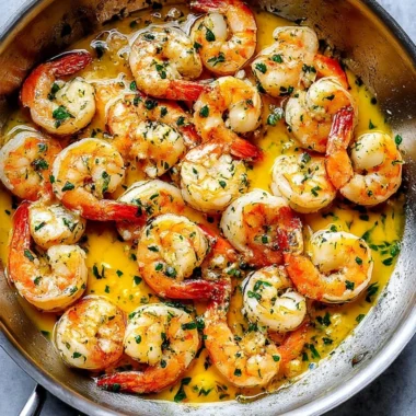 Delicious plate of shrimp scampi garnished with herbs and lemon.