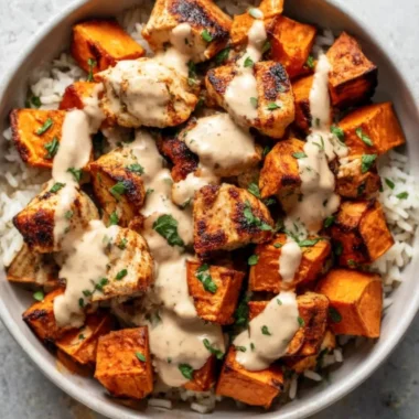 Healthy chicken rice bowl with sweet potatoes and colorful vegetables
