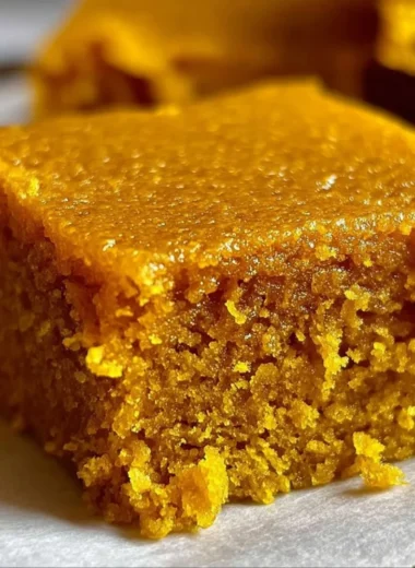 Homemade sugar free pumpkin bars topped with spices and nuts, a healthy dessert option.
