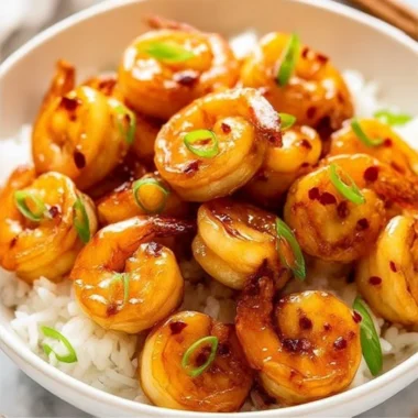 Plate of Honey Garlic Shrimp garnished with green onions and sesame seeds