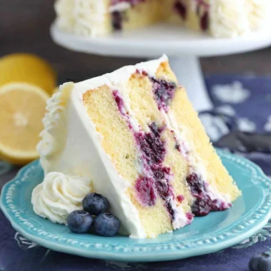 Delicious homemade lemon blueberry cake topped with fresh blueberries and lemon zest.