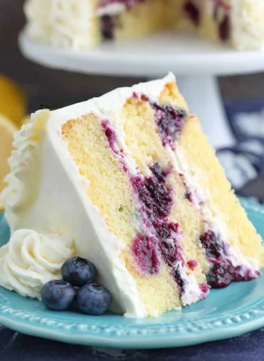 Delicious homemade lemon blueberry cake topped with fresh blueberries and lemon zest.
