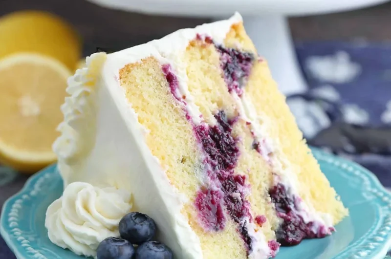 Delicious homemade lemon blueberry cake topped with fresh blueberries and lemon zest.