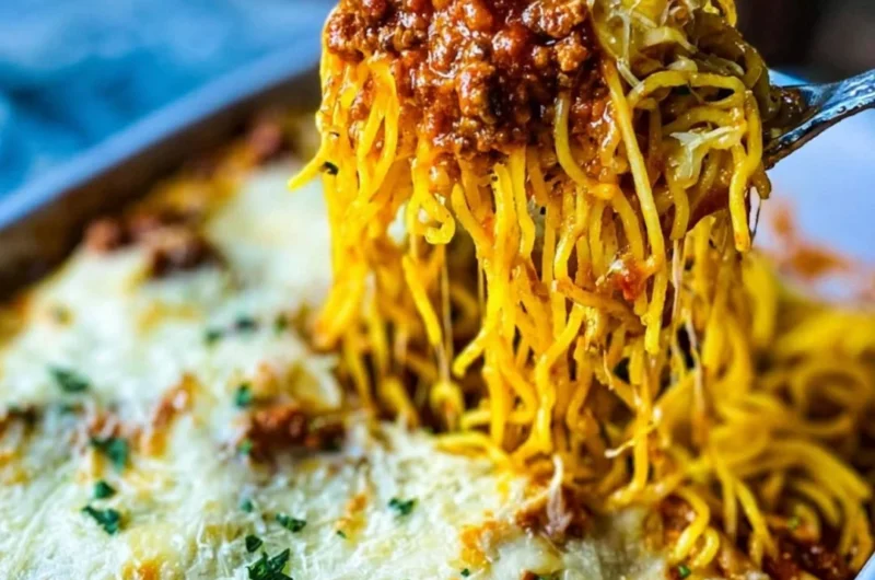 Delicious Million Dollar Spaghetti Casserole topped with cheese in a baking dish