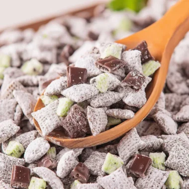 Bowl of Mint Chocolate Puppy Chow with chocolate and mint decorations