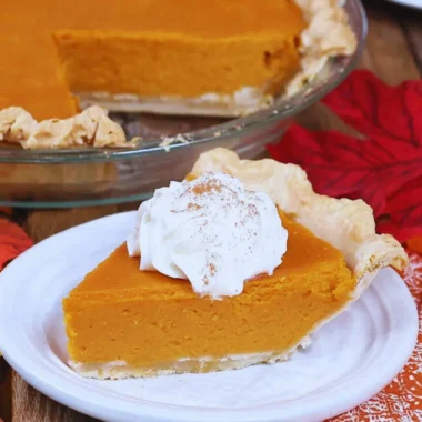 Delicious slice of my favorite sweet potato pie with vibrant orange filling on a plate.