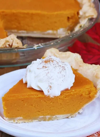 Delicious slice of my favorite sweet potato pie with vibrant orange filling on a plate.