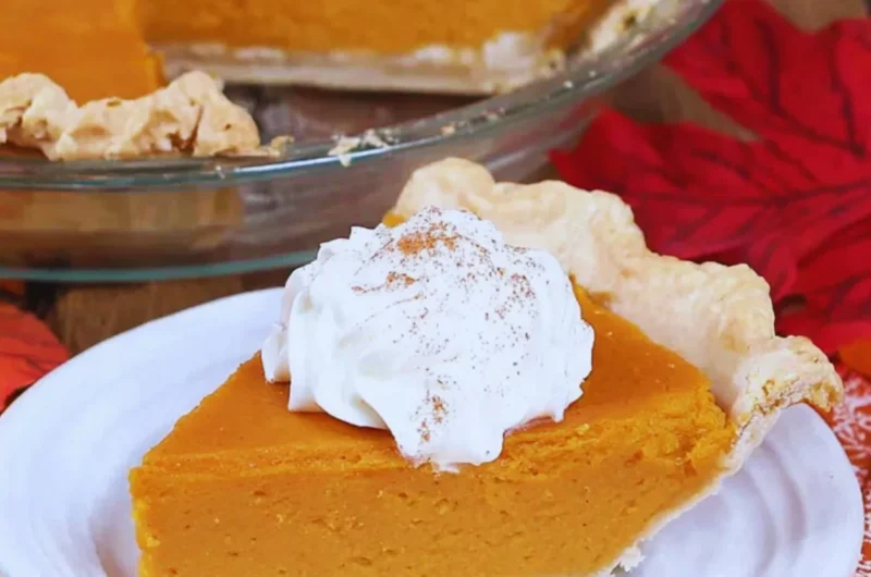 Delicious slice of my favorite sweet potato pie with vibrant orange filling on a plate.
