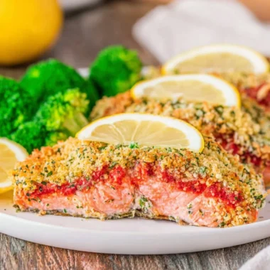Delicious Parmesan Herb Crusted Salmon served with fresh herbs and lemon.