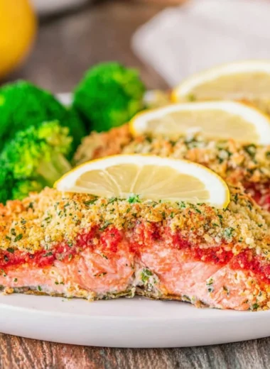 Delicious Parmesan Herb Crusted Salmon served with fresh herbs and lemon.