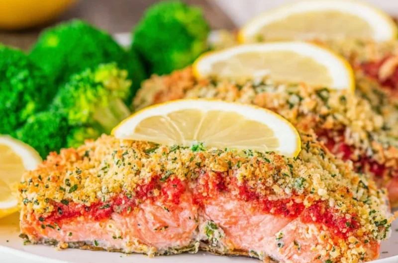 Delicious Parmesan Herb Crusted Salmon served with fresh herbs and lemon.