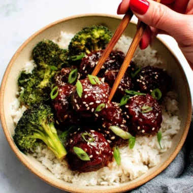 Delicious sticky Mongolian beef meatballs served with garnish on a plate.