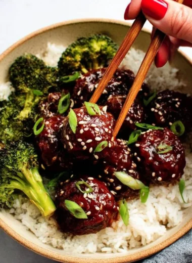 Delicious sticky Mongolian beef meatballs served with garnish on a plate.