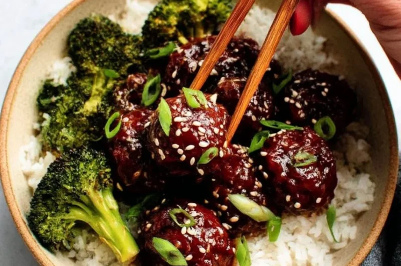 Delicious sticky Mongolian beef meatballs served with garnish on a plate.