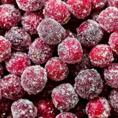 Bowl of sugared cranberries glistening with sugar, perfect for holiday decoration.