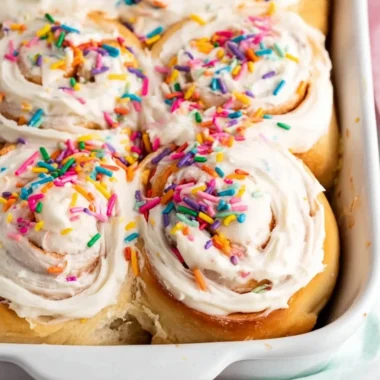 Delicious Birthday Cake Cinnamon Rolls topped with colorful icing and sprinkles