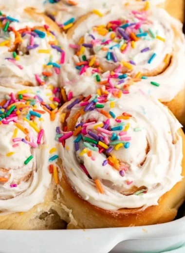 Delicious Birthday Cake Cinnamon Rolls topped with colorful icing and sprinkles