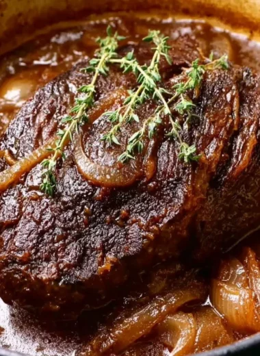Delicious Caramelized French Onion Pot Roast served with herbs and vegetables.
