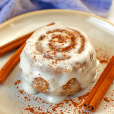 Delicious cinnamon roll baked oats topped with cream and cinnamon swirls.