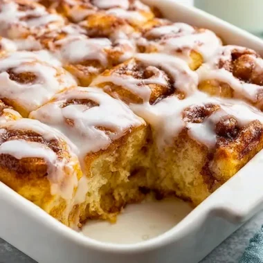 Delicious cinnamon roll casserole served warm with icing drizzle