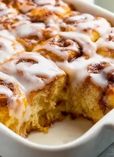 Delicious cinnamon roll casserole served warm with icing drizzle