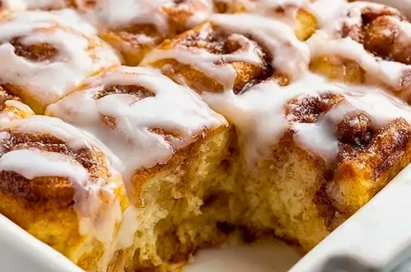 Delicious cinnamon roll casserole served warm with icing drizzle