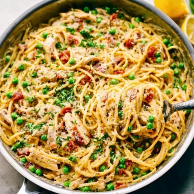 Creamy chicken carbonara pasta dish garnished with parsley.