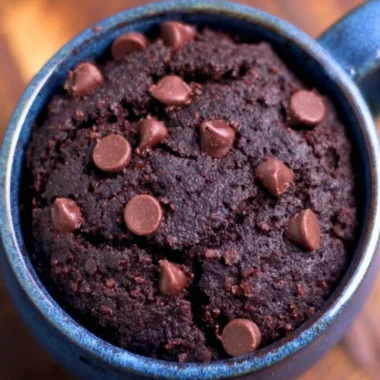 A delicious chocolate brownie mug cake served in a mug with a spoon.