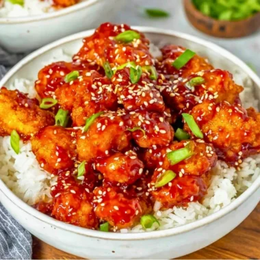 Plate of easy sesame chicken garnished with sesame seeds and green onions