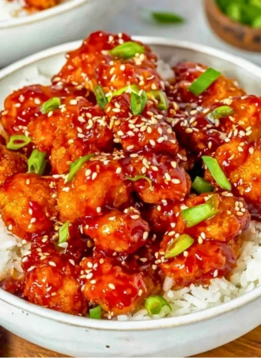 Plate of easy sesame chicken garnished with sesame seeds and green onions